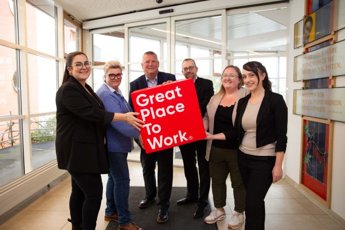 Wir sind ein Great Place to Work | © KHWE KHWE Mitarbeiterinnen und Mitarbeiter halten einen Würfel mit dem Great place to work-Logo | © KHWE